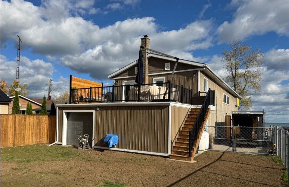 Raised backyard deck with black aluminum railings built by Kuiper Construction